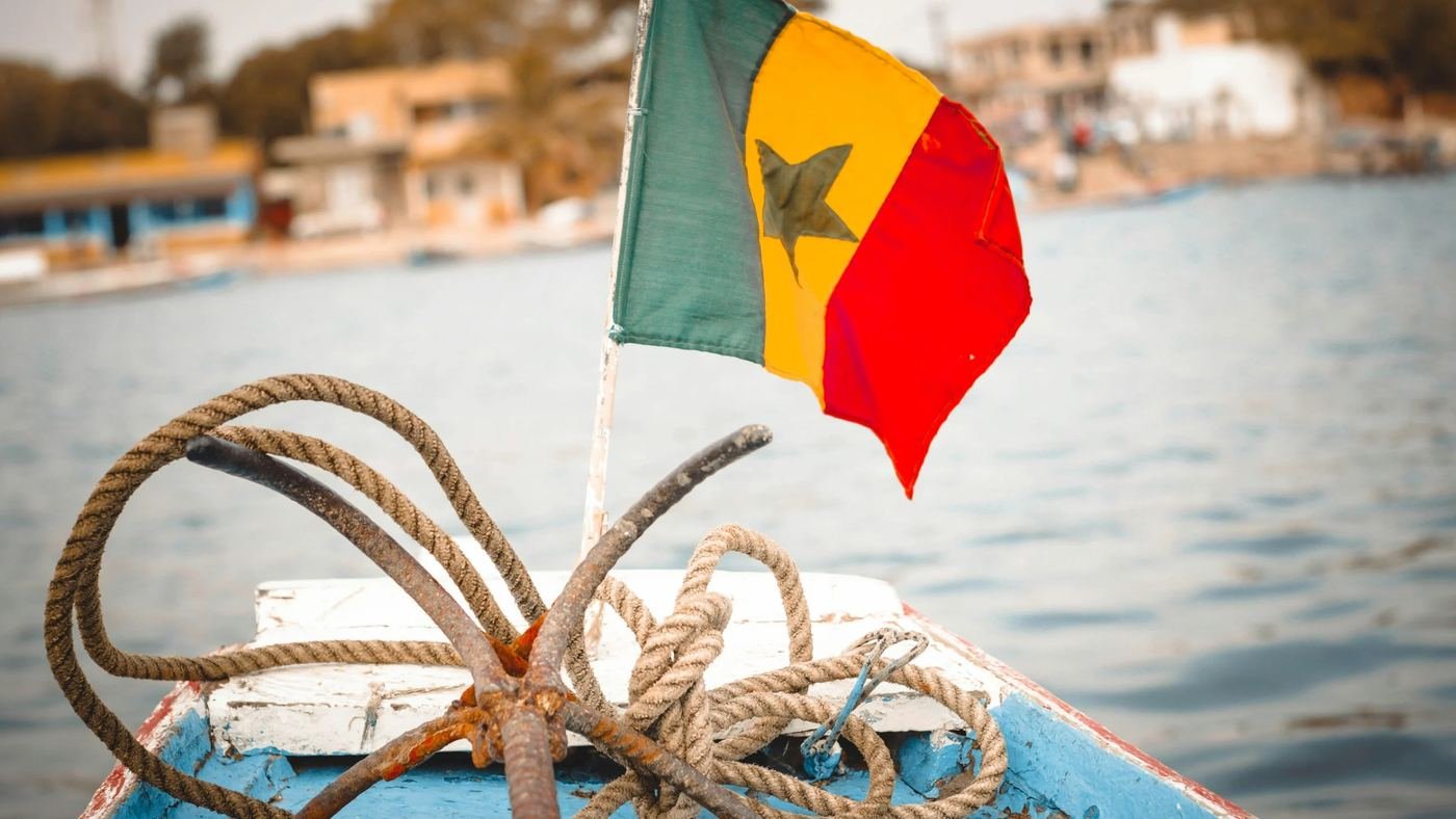 Drapeau du Sénégal à la proue d'une pirogue